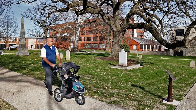 Dan Kelly pushes his grandson, Jack, as they explore the renovated Springfield Burying Ground, the oldest cemetery in the city, Thursday, Nov. 10, 2022. BILL LACKEY/STAFF