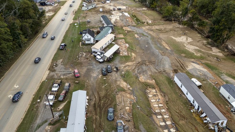 Homes and vehicles that were damaged in a flash flood from Hurricane Helene lie on the side of a road near the Swannanoa River, Tuesday, Oct. 1, 2024, in Swannanoa, N.C. (AP Photo/Mike Stewart)