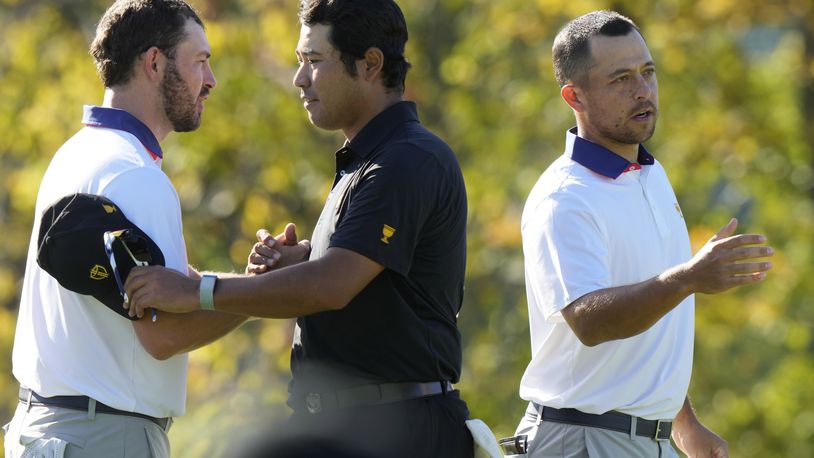 International team member Hideki Matsuyama of Japan shakes hands with United States team members Russell Henley, left, and Xander Schauffele, right, after winning their second round foursome match 7&6 at the Presidents Cup golf tournament at Royal Montreal Golf Club Friday, September 27, 2024 in Montreal. (Frank Gunn/The Canadian Press via AP)