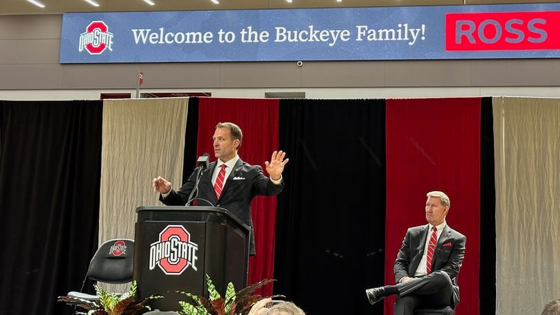 Ross Bjork speaks while Ted Carter (seated) looks on during a press conference to introduce Bjork as Ohio State's next director of athletics Jan. 17, 2024.