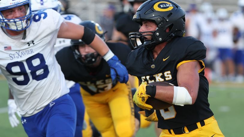 Centerville's Andrew Erwin carries the ball into the St. Xavier secondary during Friday's game. BILL LACKEY/STAFF