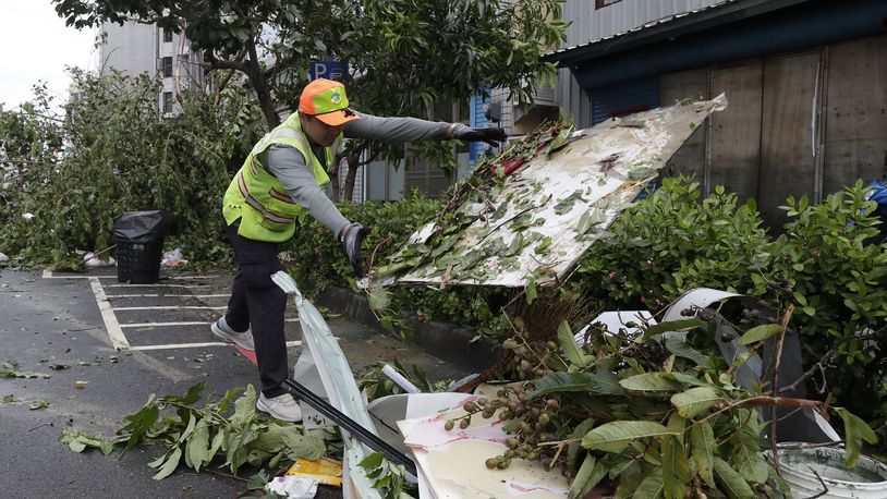 A sanitation worker of Kaohsiung city government clears debris in the aftermath of Typhoon Krathon in Kaohsiung, southern Taiwan, Friday, Oct. 4, 2024. (AP Photo/Chiang Ying-ying)