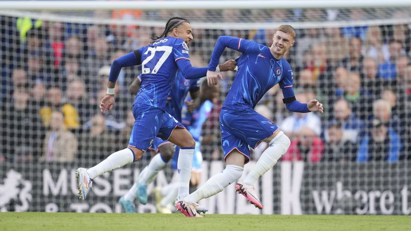 Chelsea's Cole Palmer, right, celebrates with his teammate Malo Gusto after scoring his side's 3rd goal during a British Premier League soccer match between Chelsea and Brighton at Stamford Bridge, London, Saturday, Sept. 28, 2024. (AP Photo/Kin Cheung)