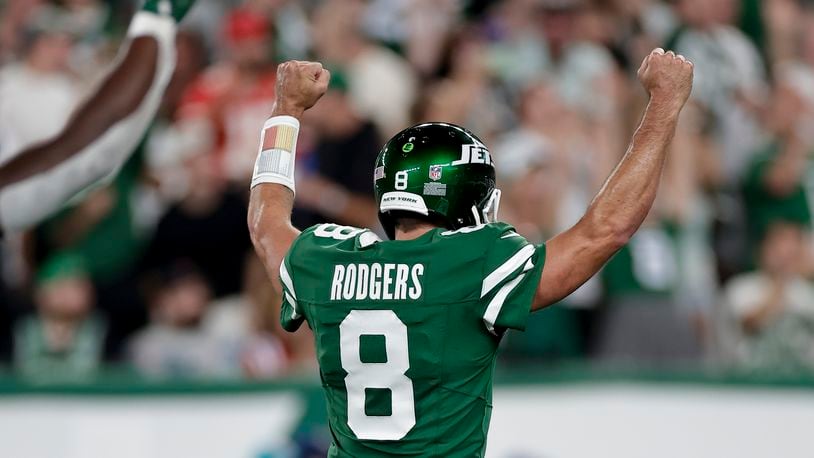 New York Jets quarterback Aaron Rodgers (8) reacts after throwing a touchdown pass against the New England Patriots during the first quarter of an NFL football game, Thursday, Sept. 19, 2024, in East Rutherford, N.J. (AP Photo/Adam Hunger)