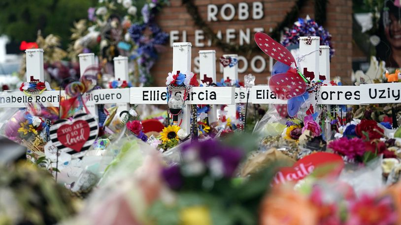 FILE - Crosses are surrounded by flowers and other items at a memorial, June 9, 2022, for the victims of a shooting at Robb Elementary School in Uvalde, Texas. (AP Photo/Eric Gay, File)