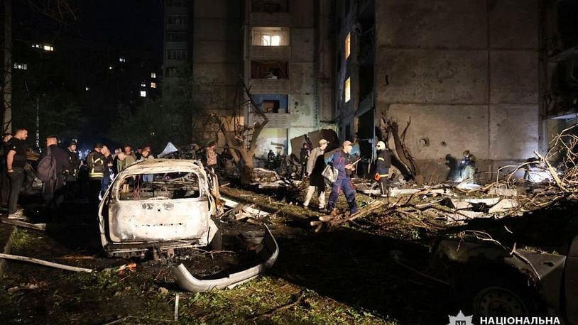 People mill around damaged cars and debris after a Russian strike on a residential building in Kharkiv, Ukraine early Sunday Sept. 22, 2024. (Ukrainian National Police via AP)