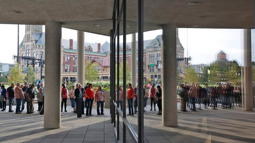 People are reflected in the windows of the Springfield City Hall Forum as they wait to be let in for the City Commission meeting Tuesday, Sept. 25, 2024. BILL LACKEY/STAFF