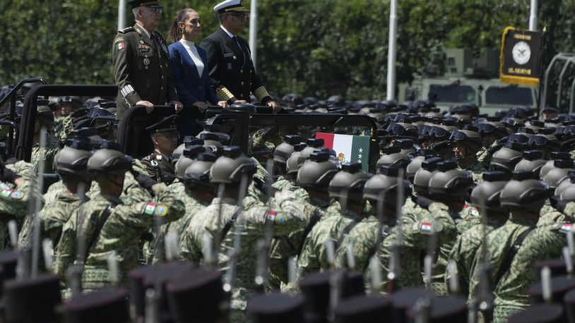 Mexican President Claudia Sheinbaum, center, reviews the troops with Defense Minister Gen. Ricardo Trevilla Trejo, left, and Navy Secretary Alt. Raymundo Pedro Morales at Campo Marte in Mexico City, Thursday, Oct. 3, 2024. (AP Photo/Fernando Llano)