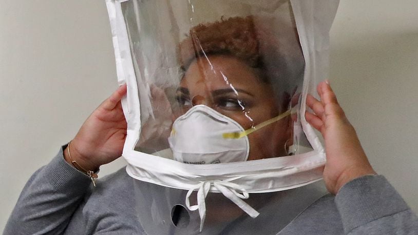 Lenora Pass moves around to make sure her N95 protective mask stays in place during her fit test Thursday. BILL LACKEY/STAFF