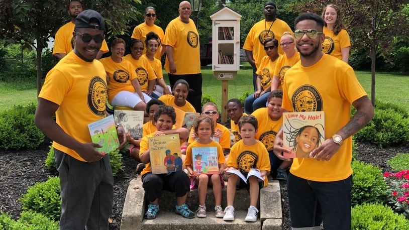 The co-founders of The Conscious Connect, Inc. Moses B. Mbeseha, left, and Karlos L. Marshall, right, in this file photo stand with children and community members at a reading park they created on Woodward Avenue in Springfield. The Conscious Connect's newest initiative will including working with teens through a reading project to help them learn how to advocate against racism. CONTRIBUTED.