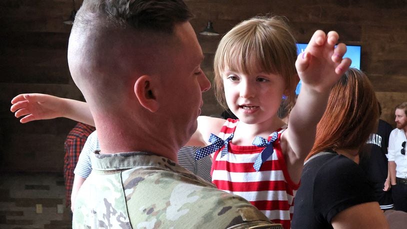 Calliope East gives her father, SSG Jacob East of the Ohio Army National Guard 1137th Tactical Installation Networking Enhanced Signal Company, a hug following a Call to Duty Ceremony for the unit Saturday, August 31, 2024 at the First Christian Church in Springfield. BILL LACKEY/STAFF