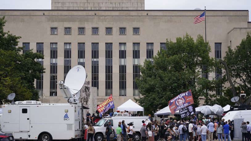 FILE - Media and protesters outside E. Barrett Prettyman US Federal Courthouse, Aug. 2, 2023, in Washington. Inside Washington’s federal courthouse, there's no denying the reality of Jan. 6, 2021. Day after day, judges and jurors silently absorb chilling sights and sounds from television screens — of rioters beating police, shattering windows and hunting for lawmakers. Hundreds of cases have systematically documented the weapons wielded, crimes committed, lives altered by physical and emotional damage. (AP Photo/Pablo Martinez Monsivais, File)