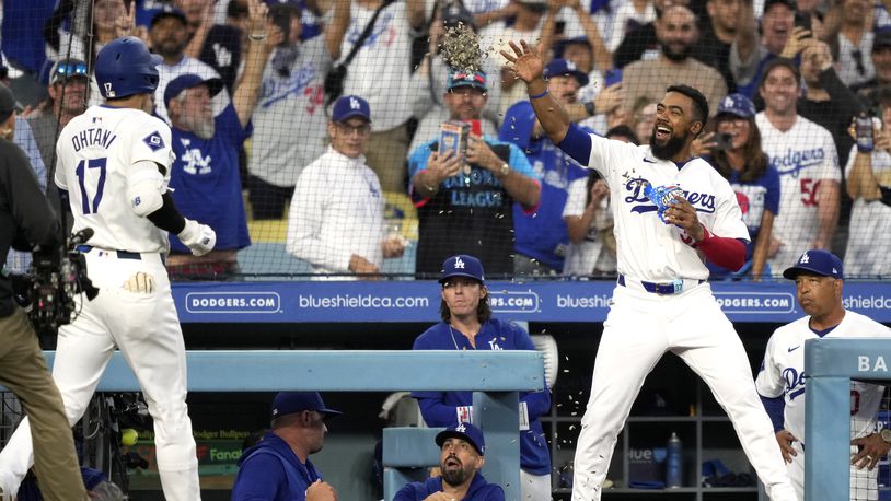 Los Angeles Dodgers' Shohei Ohtani, left, has sunflower seeds thrown at him by Teoscar Hernández after hitting a solo home run during the first inning of a baseball game against the Baltimore Orioles Thursday, Aug. 29, 2024, in Los Angeles. (AP Photo/Mark J. Terrill)