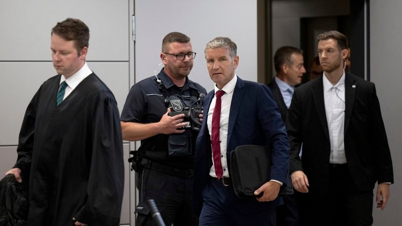 Björn Höcke, center, chairman of the Thuringian AfD, enters the courtroom of the district court shortly before the verdict is announced after his lawyer Florian Gempe, left, in Halle, Germany, Monday July 1, 2024. Höcke was convicted for the second time Monday of knowingly using a Nazi slogan at a political event. (Hendrik Schmidt/dpa via AP)