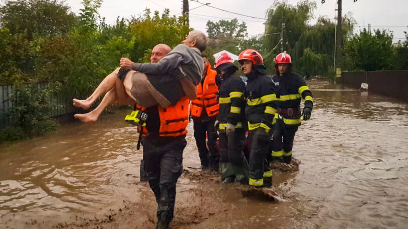 In this photo released by the Romanian Emergency Services Galati (ISU Galati), a rescuer carries an old man in Pechea, Romania, Saturday, Sept. 14, 2024 after torrential rainstorms left scores of people stranded in flooded areas. (Romanian Emergency Services - ISU Galati via AP)