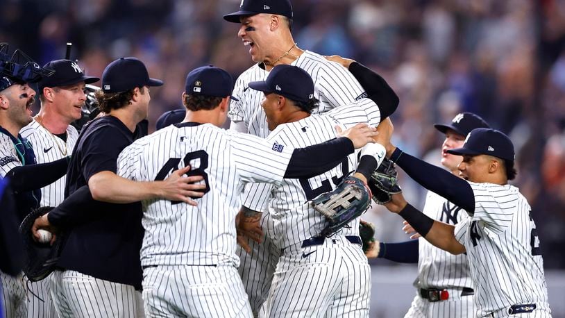 The New York Yankees, including Aaron Judge, center top, celebrate after clinching the American League East title in a baseball game against the Baltimore Orioles, Thursday, Sept. 26, 2024, in New York. (AP Photo/Noah K. Murray)