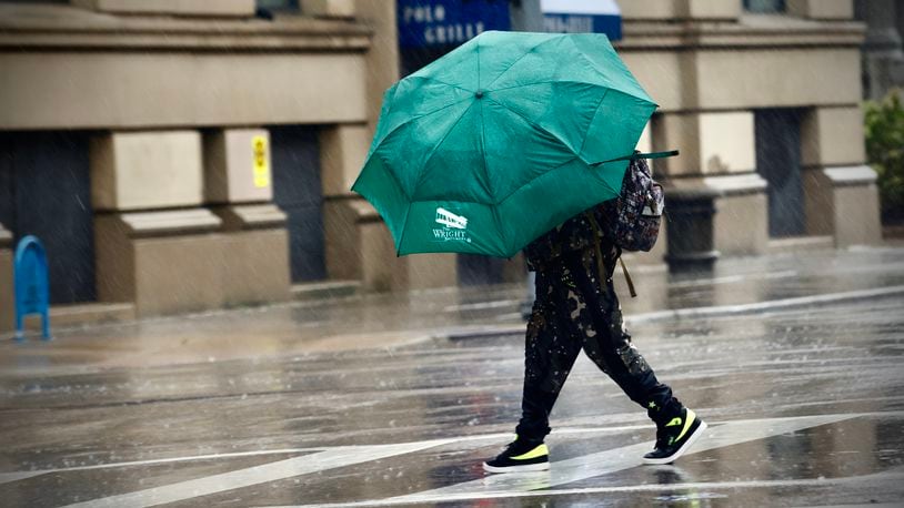 A pedestrian battles high wind and heavy rain in downtown Dayton on Friday, Sept. 27, 2024, as remnants of Hurricane Helene moved through the region. MARSHALL GORBY \ STAFF