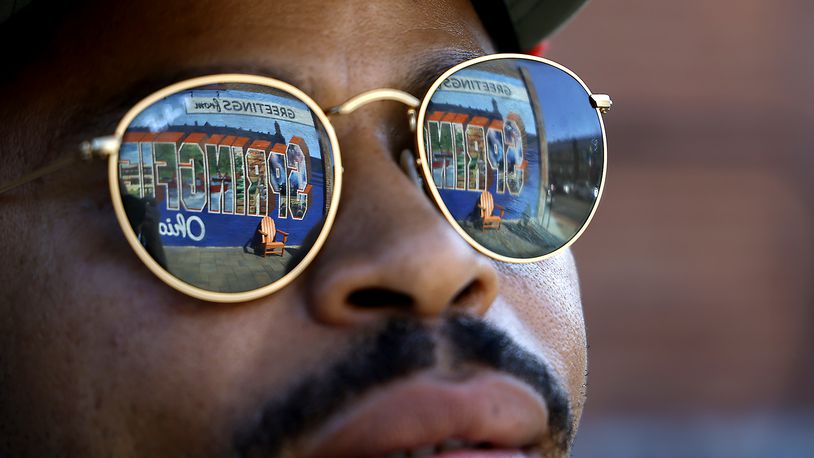 The "Greetings from Springfield" mural is reflected in William Green's sunglasses as he talks about the city and its Haitian population Wednesday, Sept. 11, 2024. BILL LACKEY/STAFF