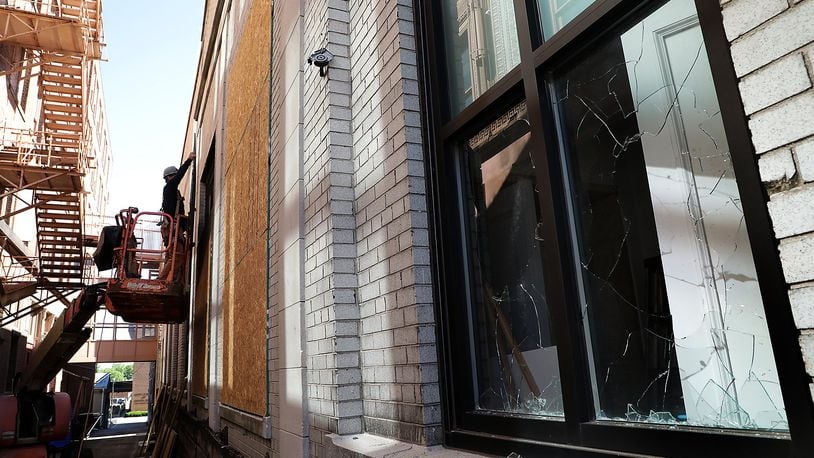 Windows at a business along Main Street are boarded up Monday morning. They were broken during Sunday night's disturbance in downtown Springfield. BILL LACKEY/STAFF