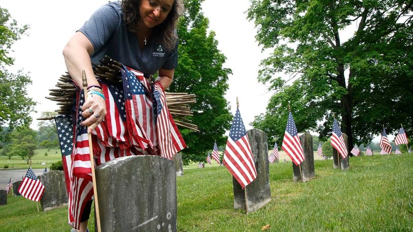 Mindy Allender joined the volunteers Saturday morning, May 18, 2024 as they placed over 3,000 American flags on the graves of service men and women interred in Ferncliff Cemetery for Memorial Day. Over 40 volunteers, including a large group from Werner Enterprises, placed flags on the central GAR (Civil War) mound, WWI section, WWII section and the Annex with more recent graves. The event was organized by Ferncliff Cemetery and Arboretum. BILL LACKEY/STAFF