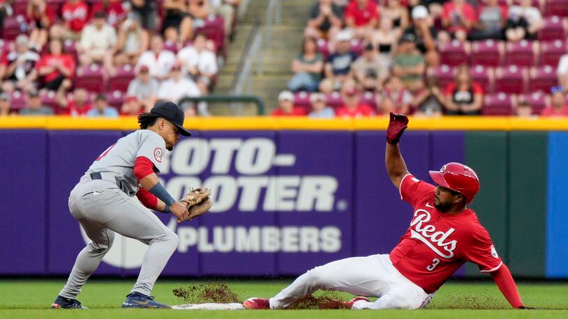 Cincinnati Reds' Jeimer Candelario (3) slides into second base with a double, next to St. Louis Cardinals shortstop Masyn Winn during the sixth inning of a baseball game against the St. Louis Cardinals Tuesday, May 28, 2024, in Cincinnati. (AP Photo/Jeff Dean)