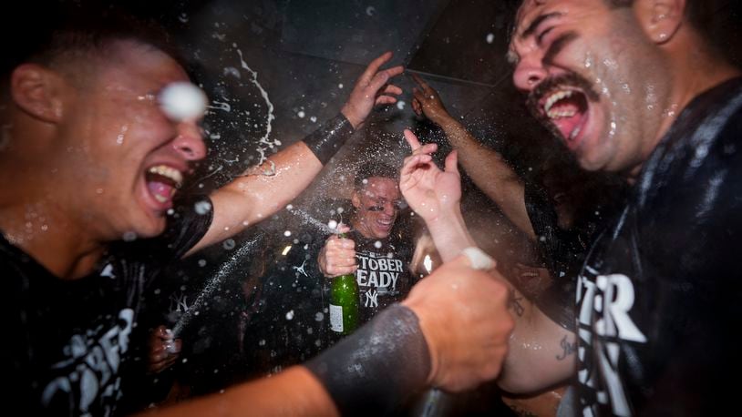 New York Yankees' Aaron Judge, center, celebrates clinching a playoff spot with teammates, including catcher Austin Wells, right, after a 2-1 win over the Seattle Mariners in a baseball game Wednesday, Sept. 18, 2024, in Seattle. (AP Photo/Lindsey Wasson)