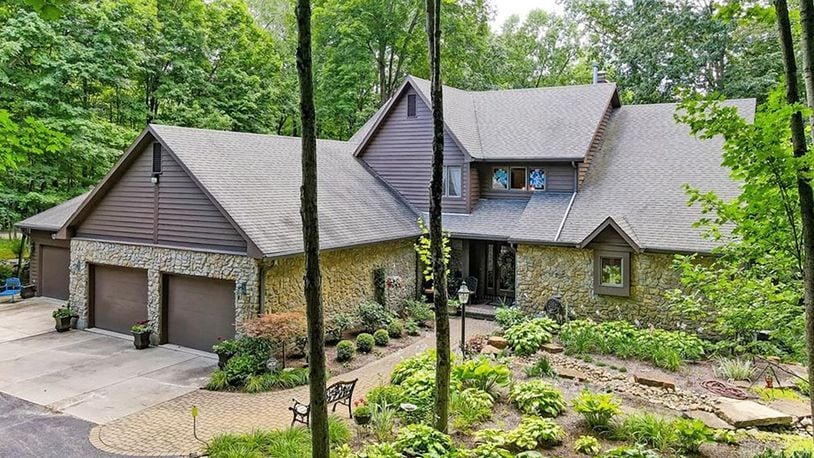 The front of the home has a four car attached garage and stone and cedar exterior as well as professional landscaping.