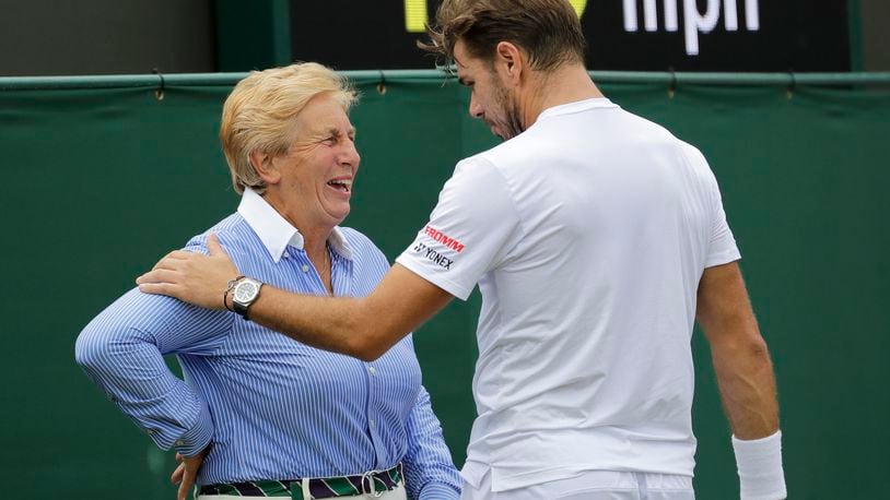 FILE - Switzerland's Stan Wawrinka jokes with a line judge in his Men's singles match against United States' Reilly Opelka during the Wimbledon Tennis Championships in London, Wednesday, July 3, 2019. That long-held Wimbledon tradition of line judges dressed in elegant uniforms is no more. The All England Club has announced that artificial intelligence will be used to make the 'out' and 'fault' calls at the championships from 2025.(AP Photo/Ben Curtis, File)