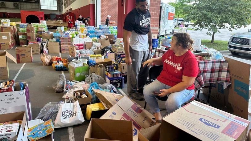 N.C. State defensive end Davin Vann and his mother, Joy Hall, work among the donations collected to help Hurricane Helene victims in western North Carolina, Wednesday, Oct. 2, 2024 in Raleigh, N.C. (AP Photo/Aaron Beard)