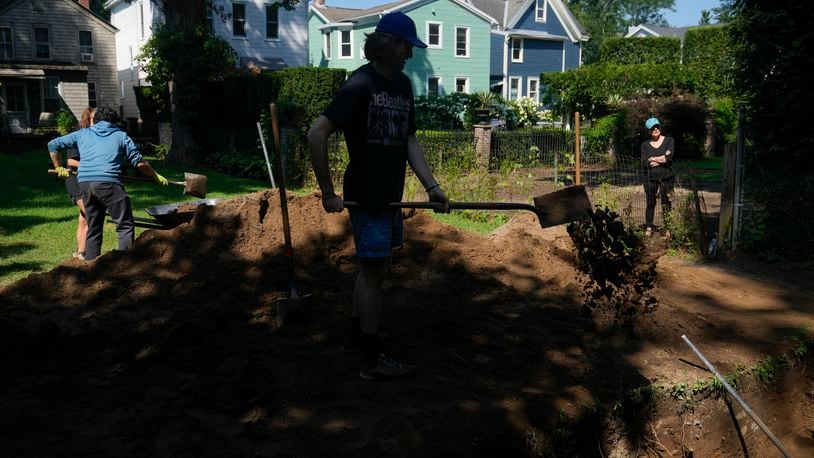 Students working at the site of an African burial ground, backfilling a hole they had dug, in Kingston, N.Y., Monday, Aug. 5, 2024. (AP Photo/Seth Wenig)