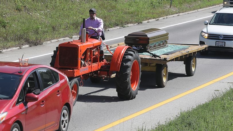 The body of Darrell Foster, a lifelong Clark County farmer, was transported from the Jackson, Lytle and Lewis Life Celebration Center to the cemetery in Lawrenceville Friday on a wagon being pulled by the antique Allis-Chalmer tractor that he had restored. Foster died last Saturday. BILL LACKEY/STAFF