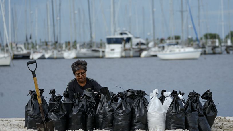 Susana Ortiz fills out sand bags on the beach at the Davis Islands Yacht Basin as she prepares for the arrival of Hurricane Milton, Tuesday, Oct. 8, 2024, in Tampa, Fla. (AP Photo/Julio Cortez)