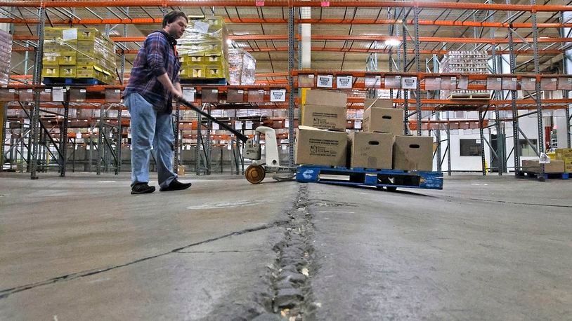 Ben Anderson pumps up the pallet jack to make it over a hump in the floor at the Second Harvest Food Bank's warehouse Wednesday, March 6, 2024. BILL LACKEY/STAFF