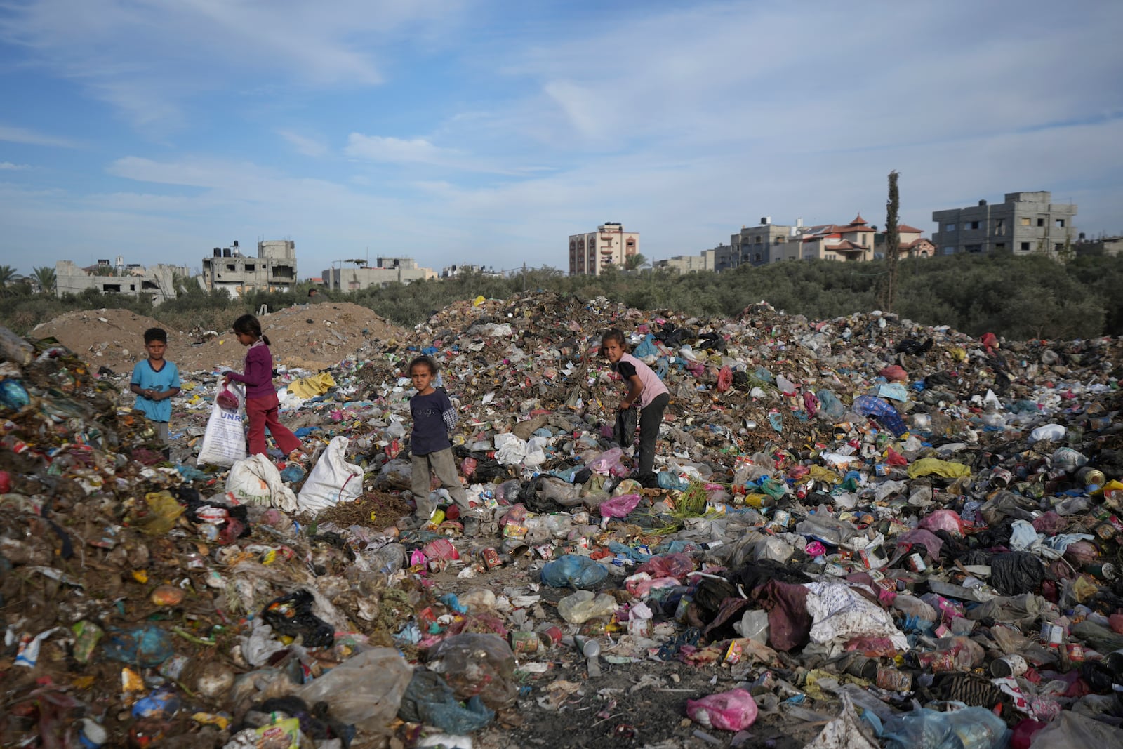 Palestinian kids sort through trash at a landfill in Zawaida, Gaza Strip, Sunday, Nov. 17, 2024. (AP Photo/Abdel Kareem Hana)