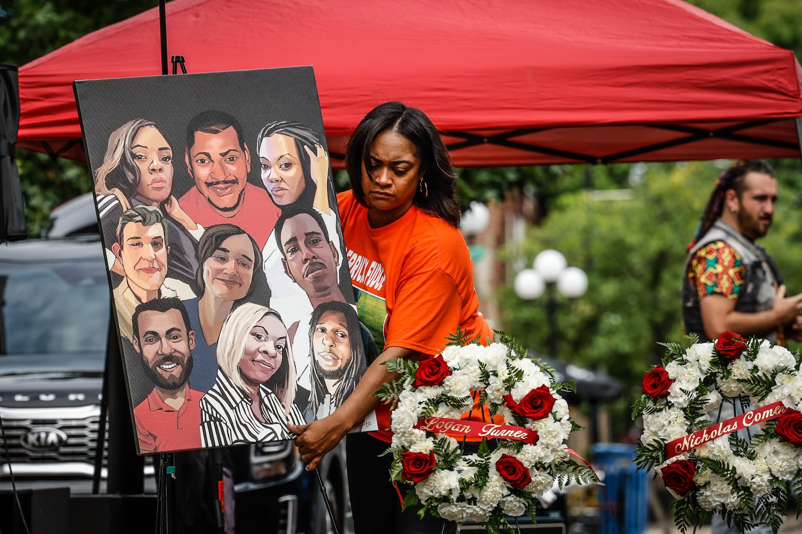 Donita Cosey sets up a painting with each of the nine the Oregon District mass shooting victims for a remembrance event Thursday, Aug. 4, 2022, on the third anniversary of the tragedy. JIM NOELKER/STAFF