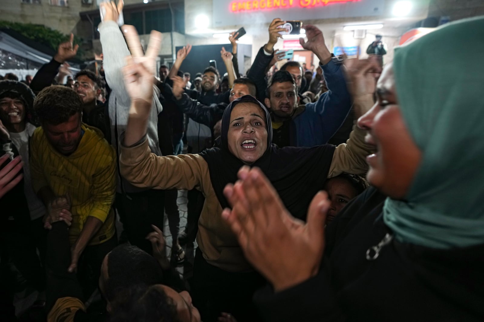 Palestinians celebrate the announcement of a ceasefire deal between Hamas and Israel in Deir al-Balah, central Gaza Strip, Wednesday, Jan. 15, 2025. (AP Photo/Abdel Kareem Hana)