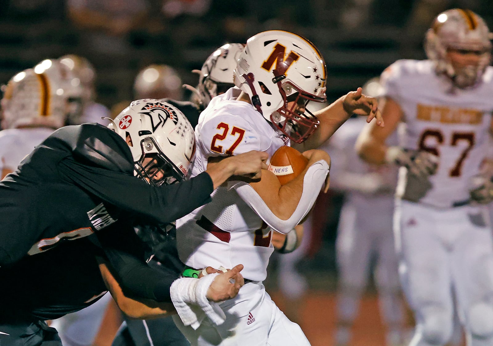 Waynesville's Carter Barnthouse tries to strip the ball away from Northwestern's Diesel Taylor as he carries the ball. BILL LACKEY/STAFF