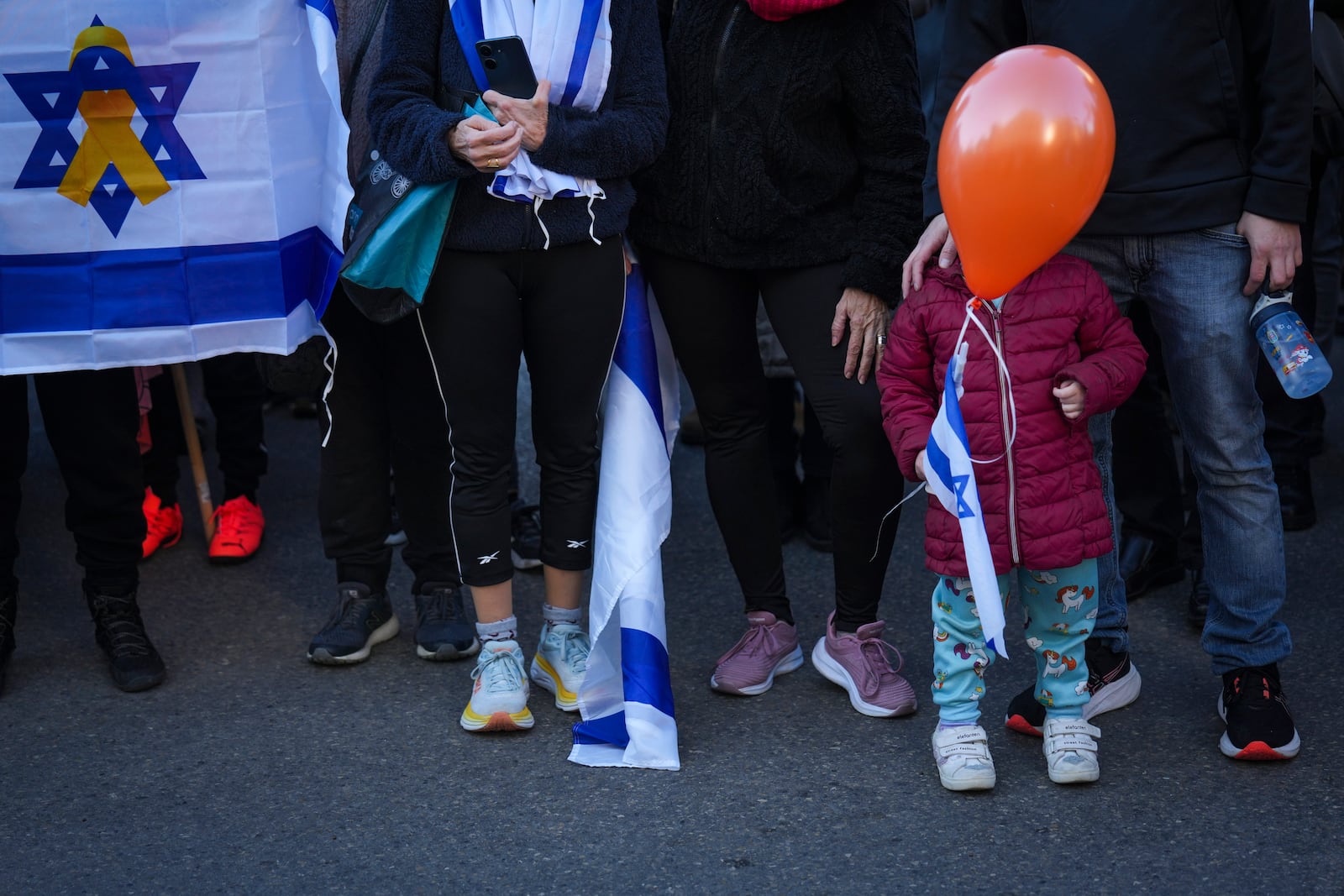 Mourners attend the funeral procession of slain hostages Shiri Bibas and her two children, Ariel and Kfir, in Rishon Lezion, Israel, Wednesday, Feb. 26, 2025. The mother and her two children were abducted by Hamas on Oct. 7, 2023, and their remains were returned from Gaza to Israel last week as part of a ceasefire agreement with Hamas. (AP Photo/Ariel Schalit)