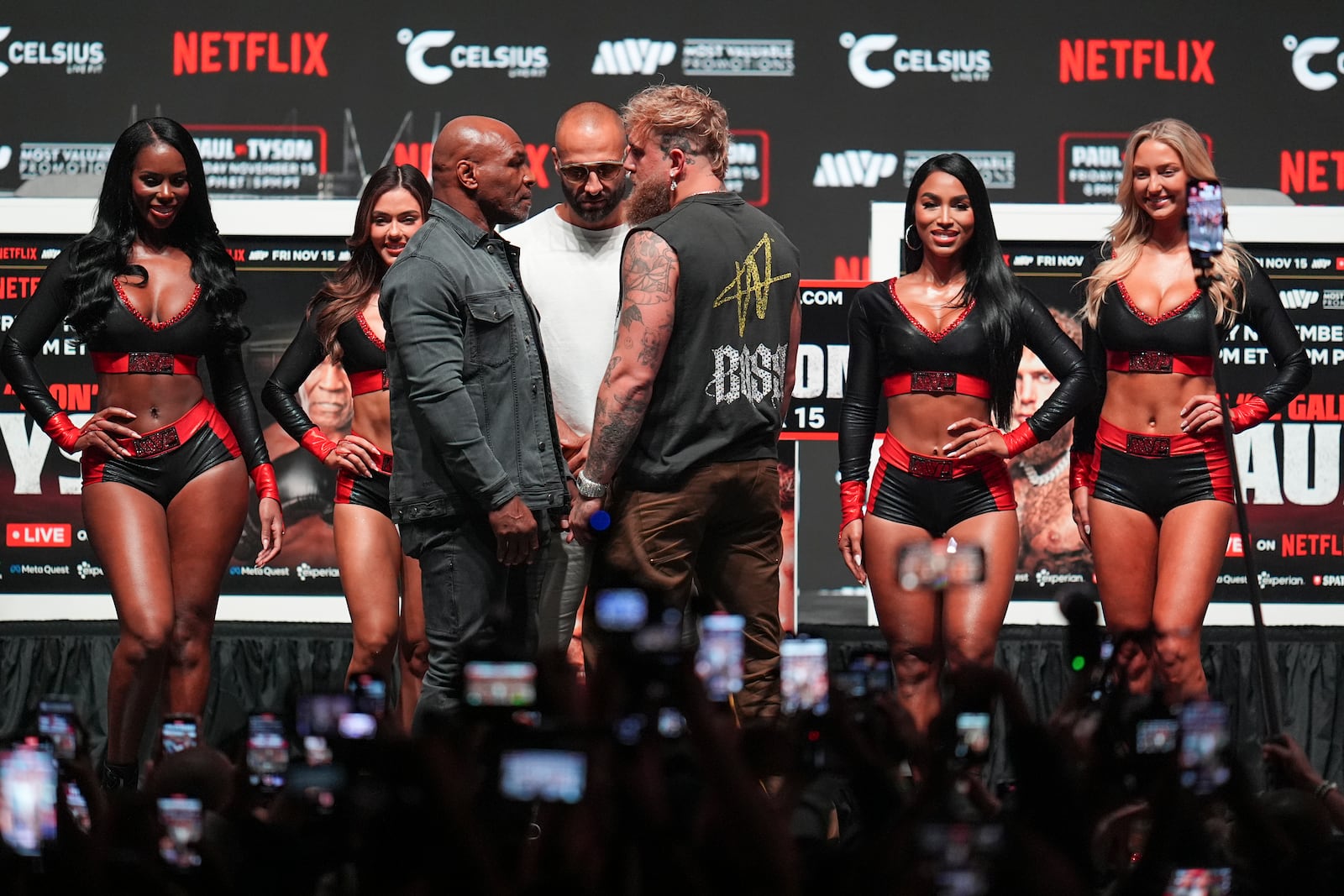 Mike Tyson, front left, and Jake Paul, front right, face off during a news conference ahead of their fight, Wednesday, Nov. 13, 2024, in Irving, Texas. (AP Photo/Julio Cortez)