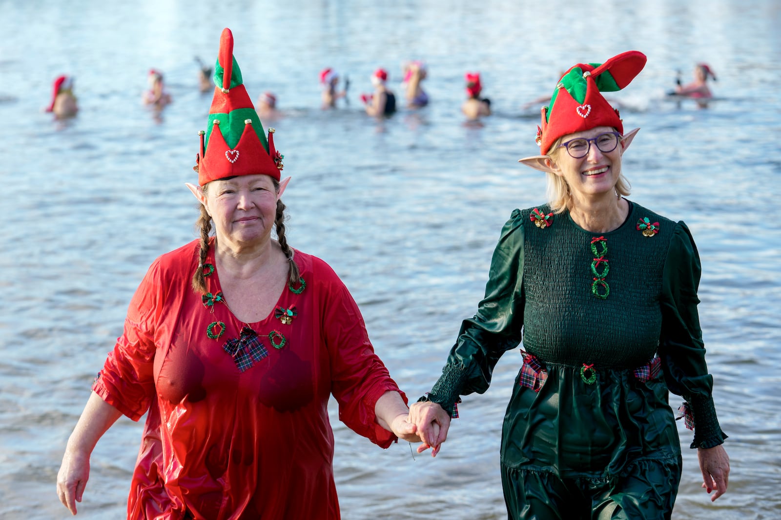 Members of the winter and ice swimming club 'Seehunde Berlin', (Berlin Seals), wearing Christmas themed hats, walk into the water during the traditional annual Christmas swim on Christmas Day, at the Oranke Lake in Berlin, Wednesday, Dec. 25, 2024. (AP Photo/Ebrahim Noroozi)