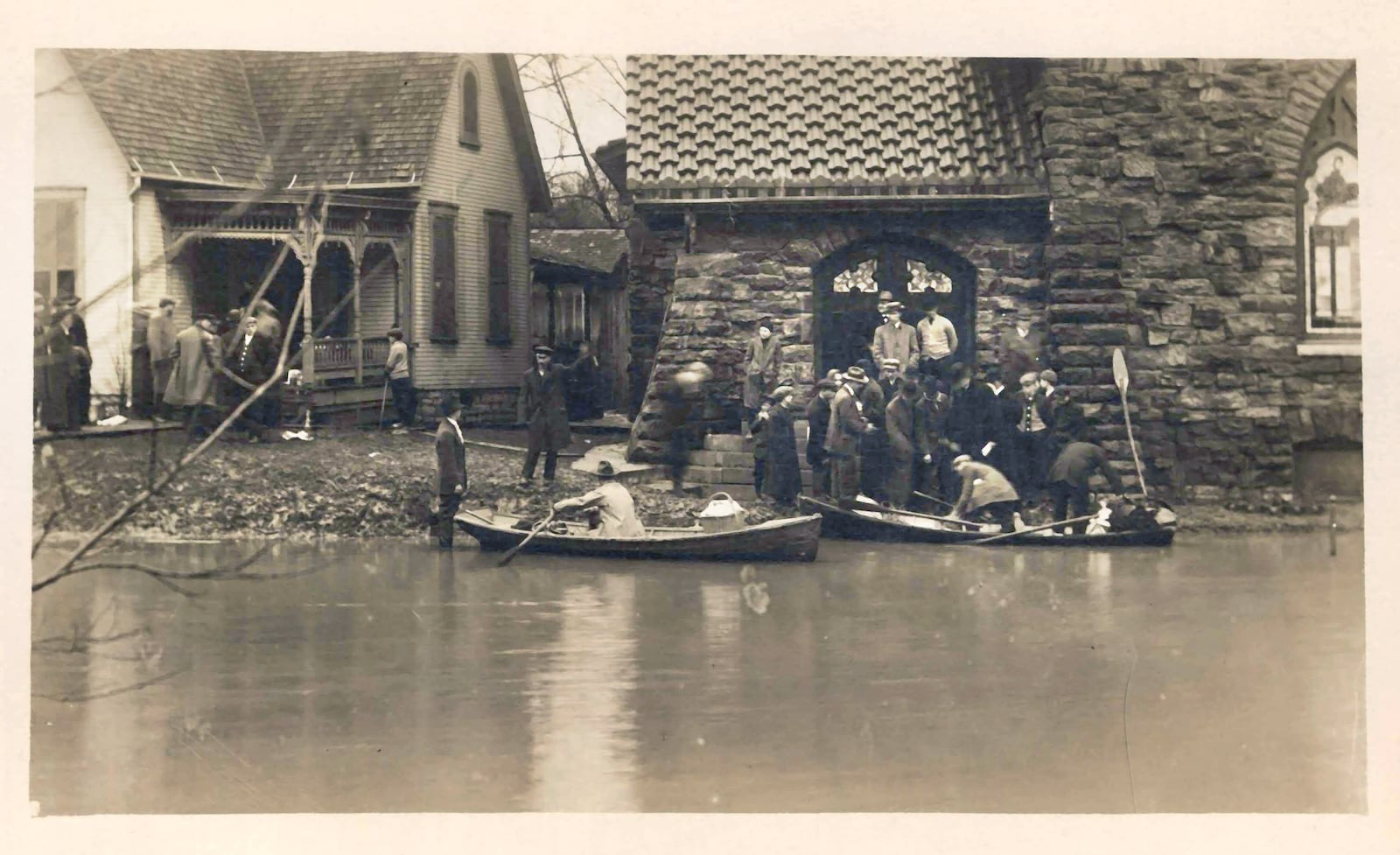 Rescue boats on Grand Avenue in Dayton during the flood of 1913. On the back of the post card is written, "Depth of water at that odd stone church Grand Ave." DAYTON METRO LIBRARY