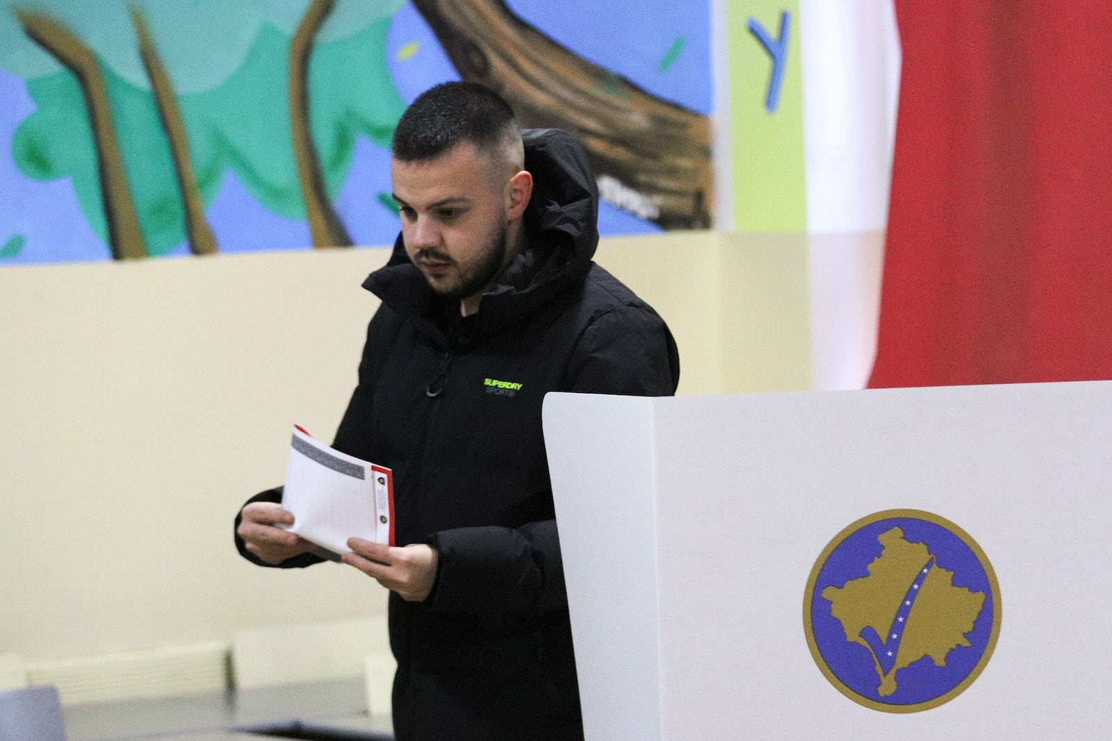 A man prepares his ballot for a parliamentary election at a polling station in the northern Serb-dominated part of ethnically divided town of Mitrovica, Kosovo, Sunday, Feb. 9, 2025. (AP Photo/Bojan Slavkovic)