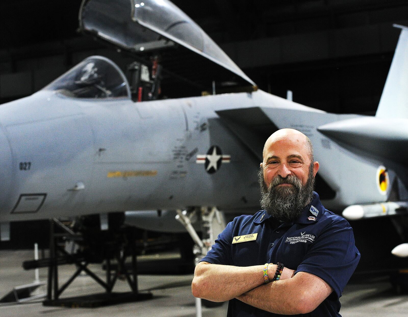 Jason Wysong, volunteer at the National Museum of the United States Air Force stands in front of a F-15 Thursday, May 5, 2023. Wysong served as a crew chief on the planes while in the Air Force.  MARSHALL GORBY\STAFF