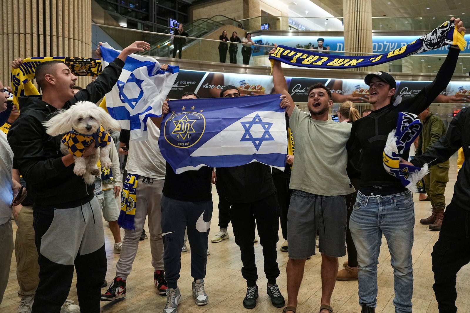 FILE - People welcome Maccabi Tel Aviv soccer fans as they arrive at Israel's Ben-Gurion International Airport on a flight from Amsterdam, where Israeli soccer fans were attacked following a match between the Israeli club and Ajax Amsterdam, in Lod, Israel, Friday, Nov. 8, 2024. (AP Photo/Tsafrir Abayov, File)