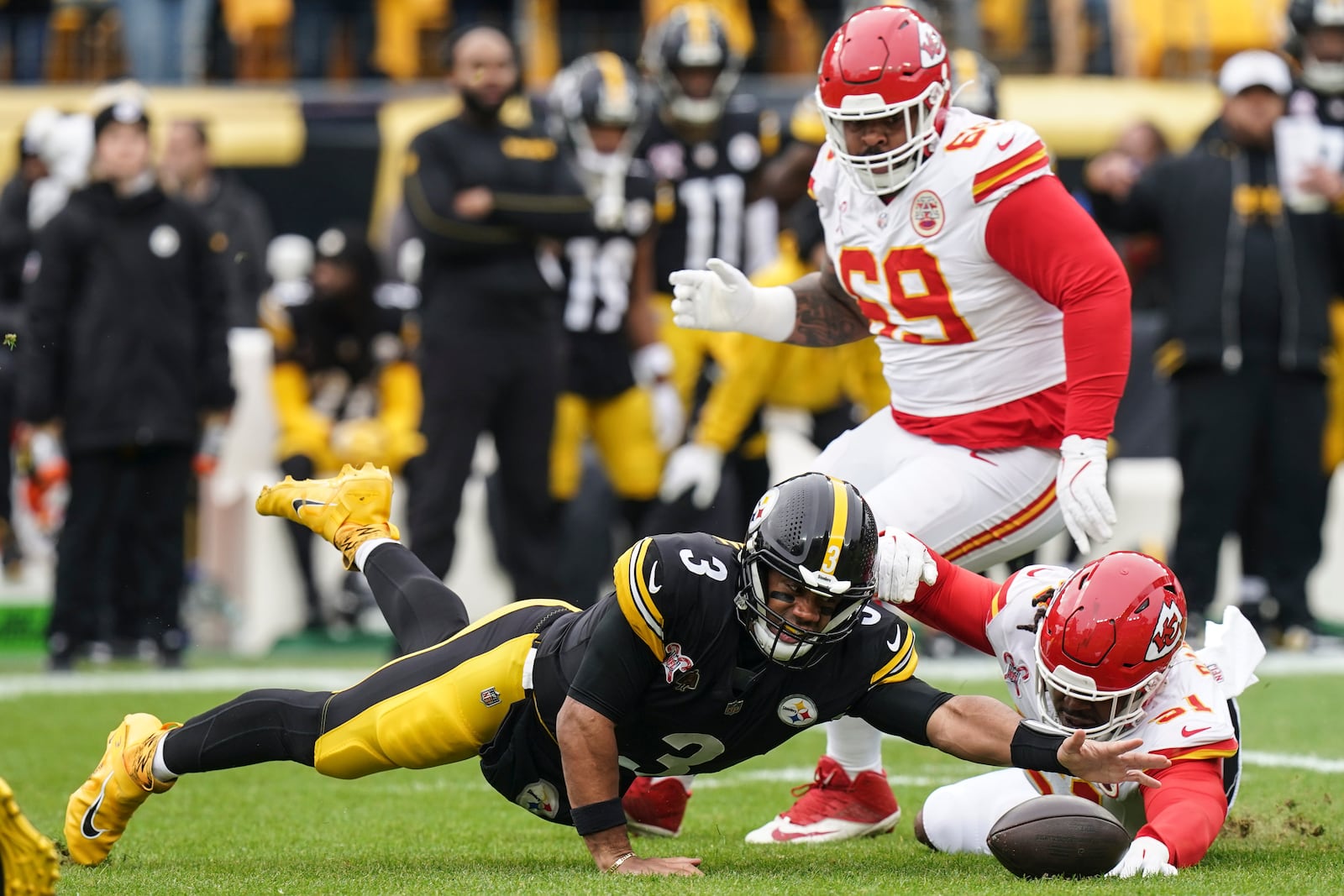 Pittsburgh Steelers quarterback Russell Wilson (3) reaches to recover his own fumble against Kansas City Chiefs defensive end Mike Danna (51) during the first half of an NFL football game, Wednesday, Dec. 25, 2024, in Pittsburgh. (AP Photo/Matt Freed)