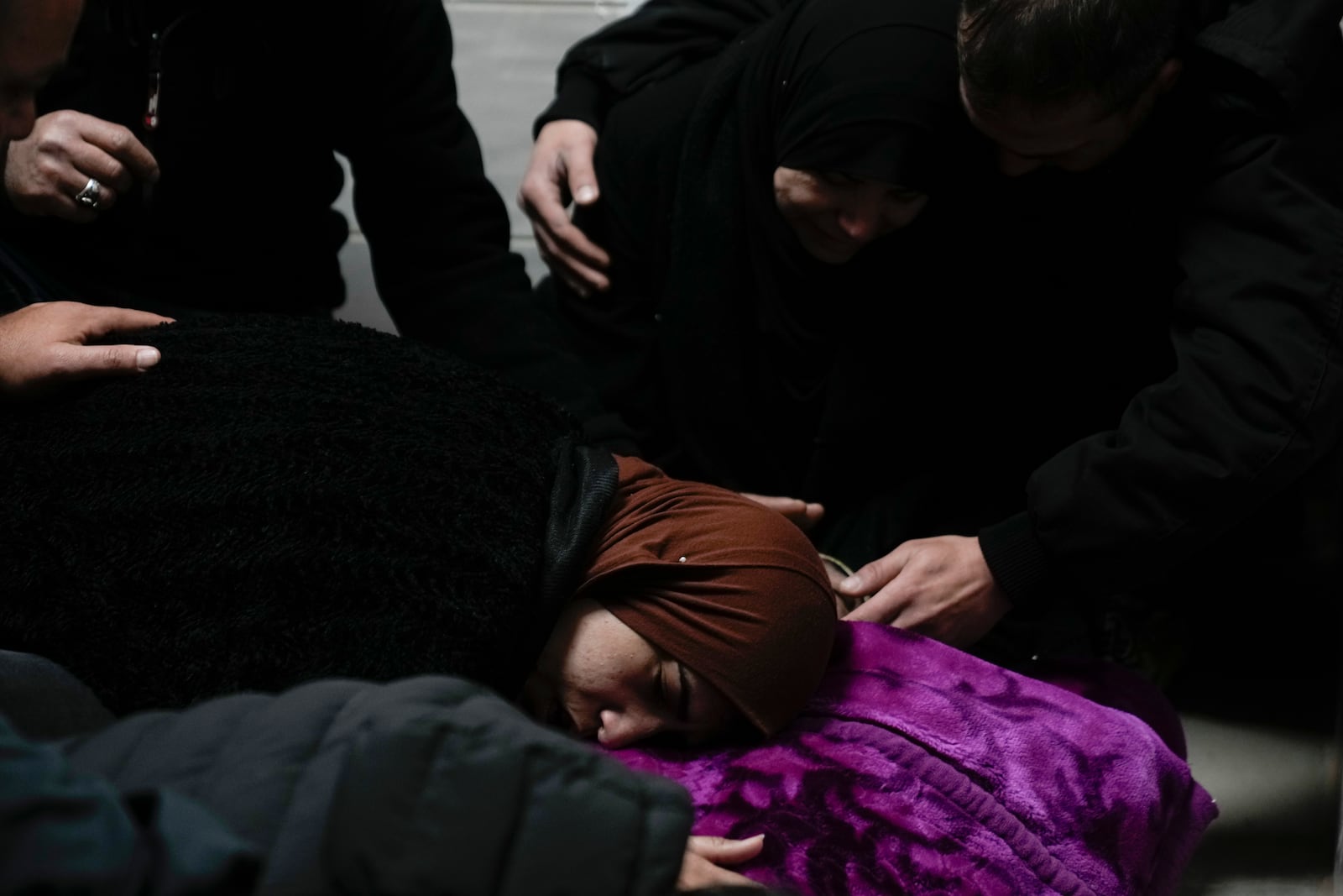 Relatives mourn over the body of Khalil Al-Saadi, 35, before his funeral, almost two weeks after he was killed in an Israeli army raid, in the hospital morgue in Jenin, West Bank, Sunday, Feb. 2, 2025. (AP Photo/Majdi Mohammed)