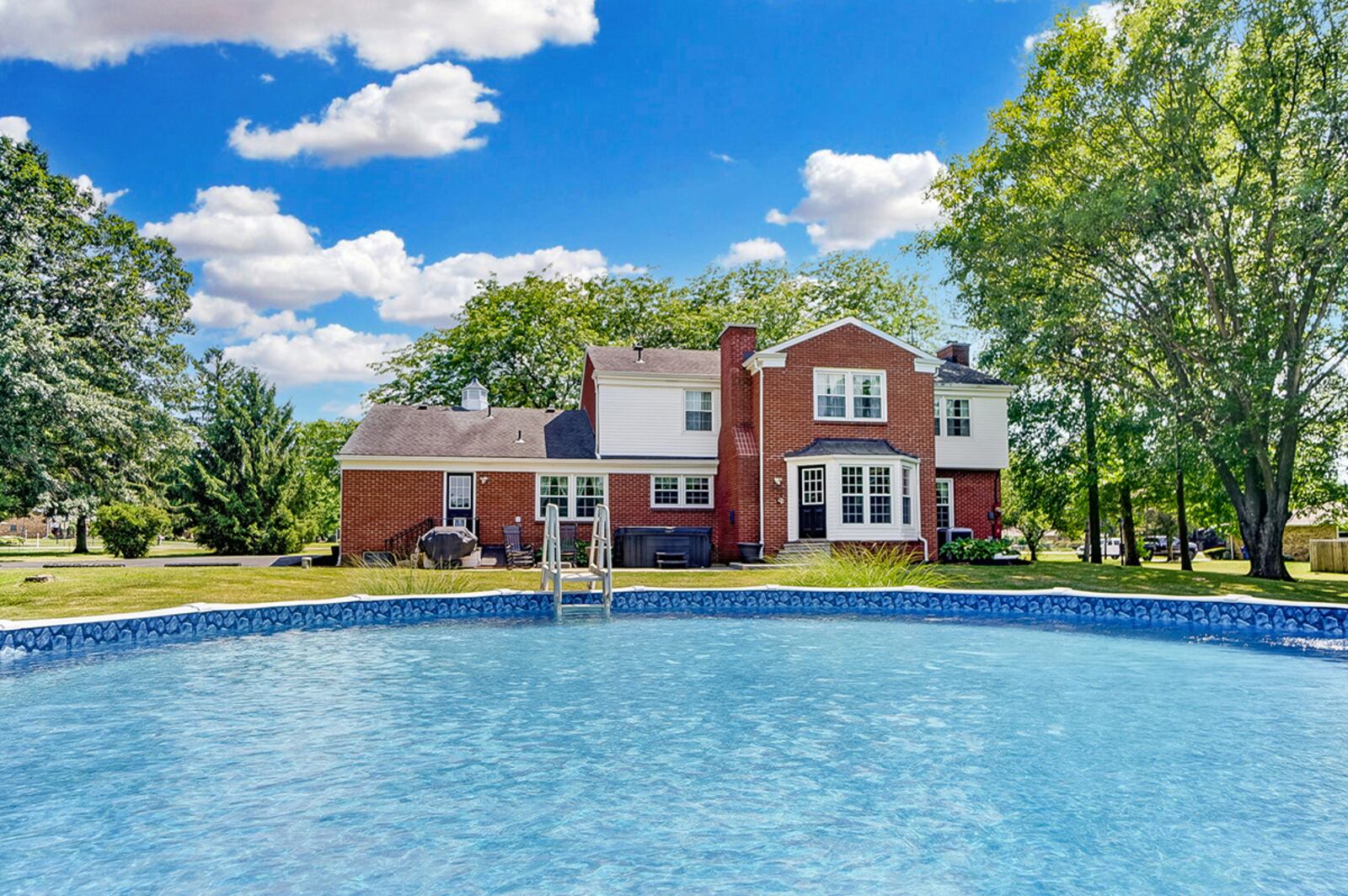 The rear of the home has a concrete curved patio extending across most of the back with a hot tub, a traditional cellar door that opens to the unfinished basement. Behind the home is also an above-ground pool built into a small hill. CONTRIBUTED PHOTO