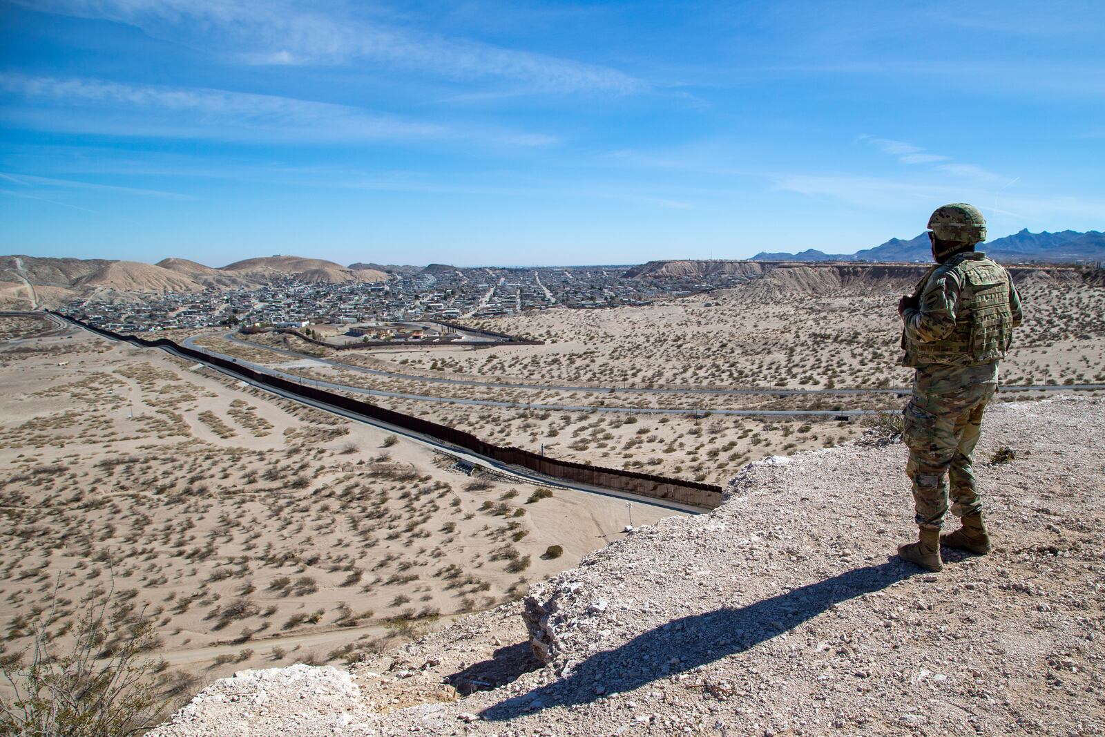 An Army soldier looks at the border wall while providing security to the visit of Defense Secretary Pete Hegseth to the US-Mexico border in Sunland Park, N.M., Monday, Feb. 3, 2025. (AP Photo/Andres Leighton)