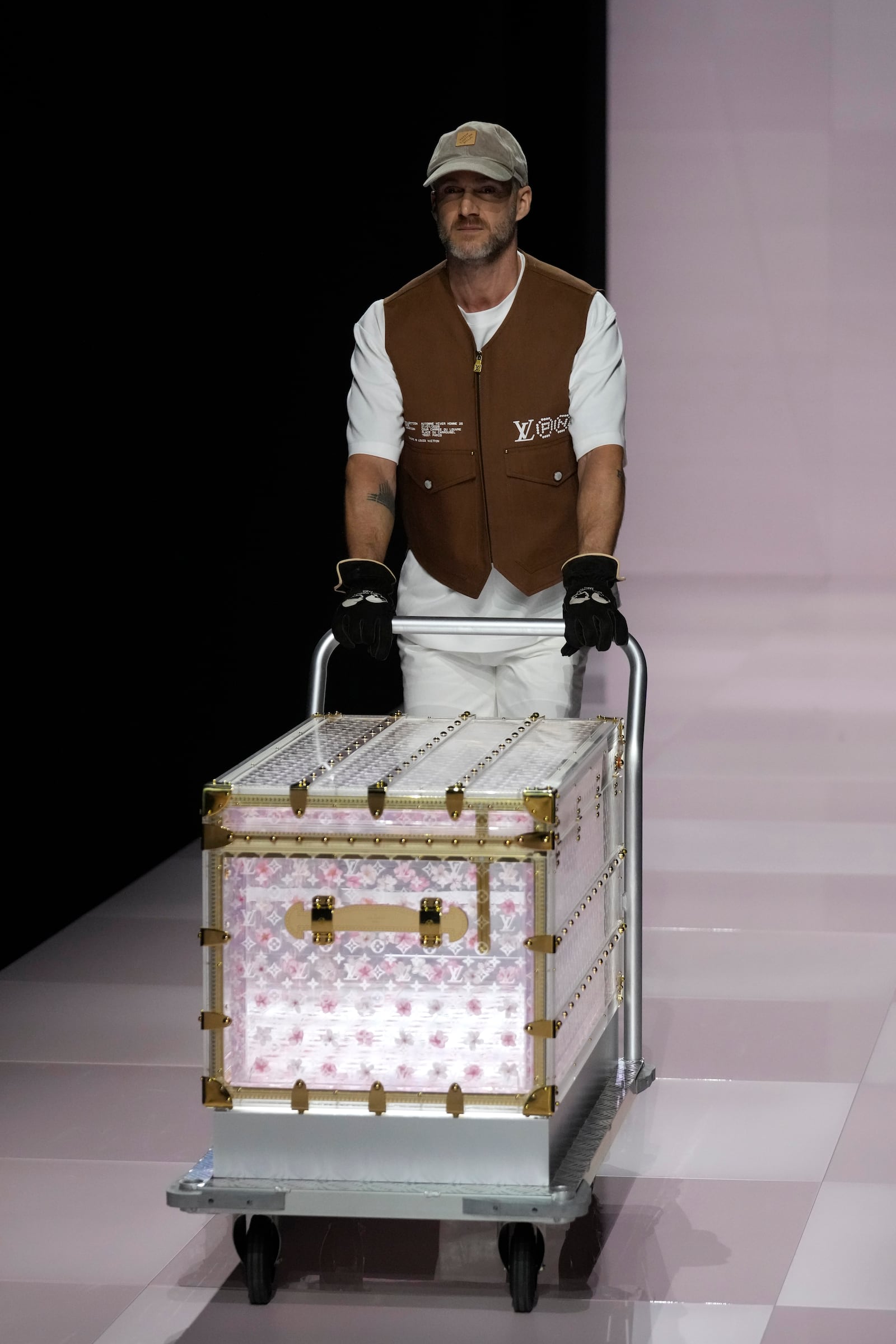 A man presents a suitcase as part of the men's Louis Vuitton Fall-Winter 2025-2026 collection, that was presented in Paris, Tuesday, Jan. 21, 2025. (AP Photo/Michel Euler)