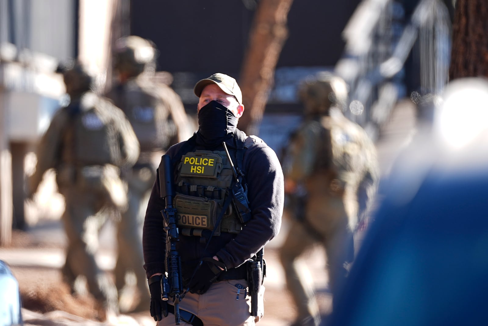 Law officials move through an apartment complex during a raid Wednesday, Feb. 5, 2025, in east Denver. (AP Photo/David Zalubowski)